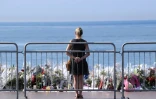 Une femme se tient le 21 juillet 2016 à Nice devant le trottoir de la Promenade des Anglais qui a été transformé en mémorial