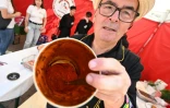 Un homme montre du paprika dans un récipient lors de la foire annuelle de Kalocsa, dans le sud de la Hongrie, le 19 septembre 2026