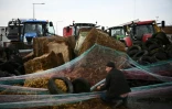 Des agriculteurs manifestant contre l'accord UE-Mercosur, érigent une barricade lors du blocage d'un dépôt pétrolier sur le port de La Pallice à La Rochelle, le 12 janvier 2026 en Charente-Maritime

