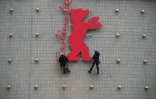Des escaladeurs industriels fixent un Ours de la Berlinale sur la façade du cinéma Zoo Palast à Berlin, le 10 février 2026