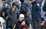 Réfugiés et migrants attendent sur une route d'être transférés dans un camp de transit à la frontière avec la Solvénie le 21 octobre à Bapska en Croatie 
