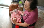 Bang Chun-ja, une Sud-Coréenne de 78 ans vivant seule, tient sa poupée IA Hyodol, le 29 avril 2026 à Yongin, en Corée du Sud