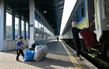 Une femme et un enfant, qui avaient fui l'Ukraine au début de la guerre, descendent du train qui les a ramenés de la Pologne à Kiev, le 12 mai 2022