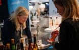 L'acheteuse de vin britannique Liz Donnelly regarde une bouteille des Côtes de Gascogne par le Domaine de Lax et prend de notes, lors du salon Wine Paris et Vinexpo Paris la Porte de Versailles, le 13 février 2024 à Paris