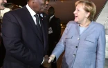 Le président ivoirien Alassane Ouattara accueille la Chancelière allemande Angela Merkel à son arrivée à l'aéroport d'Abidjan, le 28 novembre 2018