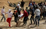 Evacuation d'un manifestant palestinien blessé par les forces de sécurité israéliennes près de la frontière entre Gaza et l'Etat hébreu, le 13 avril 2018