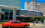 Une limousine Tchaïka soviétique des années 1970 passe devant le "Salon rouge" de l'hôtel Capri, un ancien casino fermé après la révolution castriste, à La Havane, le 14 avril 2025