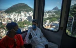 Des bénévoles qui désinfectent la favela de Santa Marta à Rio de Janeiro (Brésil), le 20 avril 2020, prennent le téléphérique