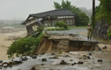 Une route et maison détruites lors de fortes inondations à Asakura, le 7 juillet 2017 au Japon
