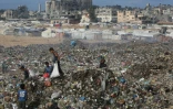 Des enfants palestiniens cherchent des objets à sauver dans un tas d'ordures près de destructions dans le camp de réfugiés de Bureij, dans le centre de la bande de Gaza, le 6 octobre 2025