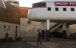 Un homme passe dans un gîte touristique construit en forme d'avion à Qaffin, dans le nord de la Cisjordanie occupée, le 2 juillet 2025 