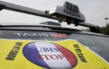 Une affiche anti-Uber sur un taxi qui bloque la porte Maillot, à Paris, le 26 juin 2015 lors d'un mouvement de grève contre le géant des véhicules de transport avec chauffeurs, Uber