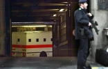 Un policier monte la garde pendant qu'un fourgon, transportant l'imam radical Abdullah al-Faisal, arrive dans un tribunal londonien, le 7 mars 2003