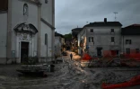 Un habitant dans les rues boueuses de Lauriano, à la suite de fortes intémpéries, le 17 avril 2025 dans le nord-ouest de l'Italie 