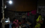 Une famille chez elle, en Inde, à Anandpur, le 23 avril 2016, alors que l'électricité vient enfin d'être installée