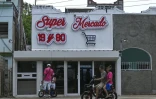 Des passants discutent devant une épicerie privée à La Havane, le 22 juin 206