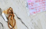 Un chapelet et un message déposés au pide de la statue de Jean-Paul II devant l'hôpital Gemelli à Rome où le pape François est soigné pour une pneumonie, le 14 mars 2025