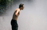 Un homme se rafraîchit sous une fontaine de Portland (Etats-Unis), le 28 juin 2021