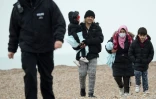 Des migrants débarqués d'un canot de sauvetage de la RNLI sur une plage de Dungeness, sur la côte sud-est de l'Angleterre, le 24 novembre 2021