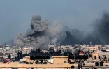 Une photo prise depuis Rafah montre un nuage de fumée noire au dessus de Khan Younès lors d'un bombardement israélien dans le sud de la bande de Gaza, le 9 février 2024
