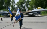 Des militaires ukrainiens passent devant chasseurs F-16 après une cérémonie dans un lieu tenu secret en Ukraine, le 4 août 2024