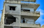 Des habitants dans un immeuble endommagé par une frappe israélienne octurne à Tyr, dans le sud du Liban, le 16 mai 2026