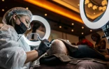 Un tatoueur spécialisé dans le tatouage du cuir chevelu lors d'un concours à Naha, dans la préfecture d'Okinawa, au Japon, le 8 juillet 2026