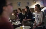 Des hommes et des femmes face à face lors d'un "shhh dating" ou rencontre silencieuse, dans un bar à l'est de Londres le 23 septembre 2015