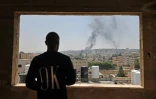 Un Palestinien regarde par la fenêtre la fumée qui s'élève après une frappe israélienne à Jénine, en Cisjordanie occupée, le 3 juillet 2023