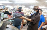 Des clients masqués essaient un chapeau dans un magasin de Garland, au Texas, en juillet 2020