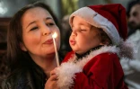 Un enfant souffle une bougie à la messe du matin de Noël à l'église orthodoxe grecque Saint-Porphyre de Gaza le 7 janvier 2025