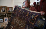 Un vendeur montre un tapis dans sa boutique à Bamiyan, le 7 janvier 2021 en Afghanistan