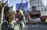 Une grue livre les ailes provisoires du Moulin Rouge, Ă Paris, le 24 juin 2024