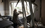 Une femme ramasse des débris pour les jeter dehors d'un appartement endommagé par un tir de missile à Kramatorsk, est de l'Ukraine le 5 mai 2022