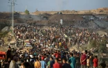 Des Palestiniens rassemblés à un point de distribution d'aide mis en place par la Fondation humanitaire de Gaza (GHF), près du camp de réfugiés de Nousseirat, dans le centre de la bande de Gaza, le 25 juin 2025