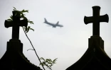 Un avion passe au-desusus du cimetière dans le village abandonné de Goussainville, le 26 novembre 2013, dans le Val-d'Oise