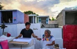 Un jeune accompagné de sa grand-mère se prépare à nettoyer les restes d'un proche avant les célébrations du Jour des Morts au cimetière de Pomuch, dans l'État de Campeche, au Mexique, le 18 octobre 202