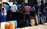Un soldat monte la garde pendant que des habitants font la queue à une station-services, le 29 mars 20222 à Colombo, au Sri Lanka