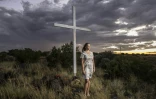 Doret Le Cornu, 23 ans et ayant emménagé il y a trois ans à Orania pose devant une croix dans cette enclave afrikaner de la province du Cap septentrional en Afrique du Sud, le 29 janvier 2026.