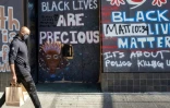 Un Afro-Américain passe devant un mur couvert de messages Black Lives Matter à Oakland, en Californie, le 12 février 2021