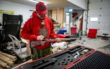 Le ranger Les Paulson montre une arme utilisée par les rangers canadiens, le 23 janvier 2025 à Yellowknife, dans les Territoires du Nord-Ouest, au Canada