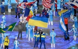 Les porte-drapeaux dont celui de l'Ukraine Vitalii Lukianenko, défilent lors de la cérémonie de clôture des Paralympiques des Pékin, le 13 mars 2022