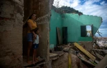 Une femme et sa fille dans les ruines de leur maison sur la plage d'Atafona, le 7 février 2022 au Brésil