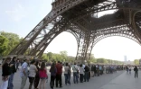 Des visiteurs en file d'attente sous la Tour Eiffel le 21 avril 2011 à Paris