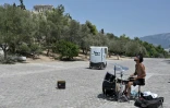 Un musicien dans une zone touristique désertée par les touristes en raison de la canicule, à Athènes, le 29 juillet 2021. 