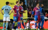Le défenseur du FC Barcelone Ronald Araujo (allongé sur la civière, en arrière-plan), victime d'une coup sur la tête, est introduit dans une ambulance sur la pelouse du Camp Nou lors du match contre le Celta Vigo, en championnat d'Espagne à Barcelone, le 10 mai 2022
