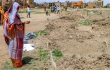 Une femme récite une prière devant des tombes dans le quartier d'Al-Azhari dans la banlieue de Khartoum, le 2 août 2025