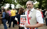 Le député de la formation "Ecologiste et Social", Benoît Biteau, pose avec une pancarte sur laquelle on peut lire "cadmium, poison" lors d'une manifestation sur l'esplanade des Invalides à Paris, le 2 juin 2026