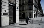 A Paris sur les Champs-Elysées désertés par ses flâneurs et touristes, un sans domicile fixe erre, le 23 mars 2020