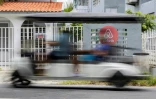 Une voiturette de golf passe devant une villa en Airbnb à Vega Baja, le 13 Juillet 2025 à Porto Rico
